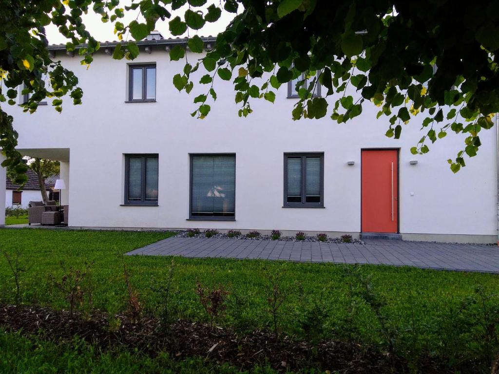 a white house with a red door at Reusenhaus Nord in Breege