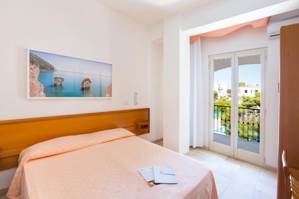 a bedroom with a bed and a large window at Hotel Mediterraneo in Vieste