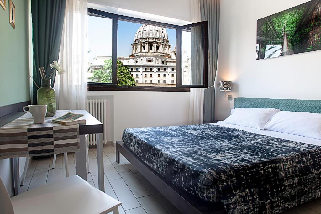 ローマにあるセント ピーターズ ビューのベッドルーム1室(ベッド1台、テーブル、窓付)