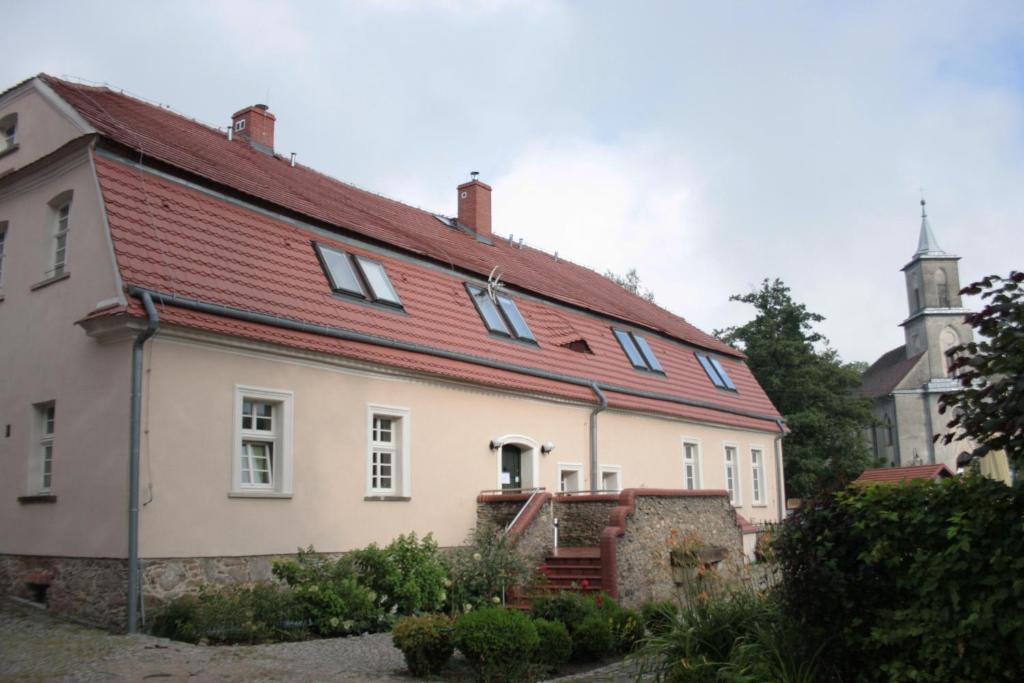 a large white house with a red roof at Karczma Bełty in Glinno