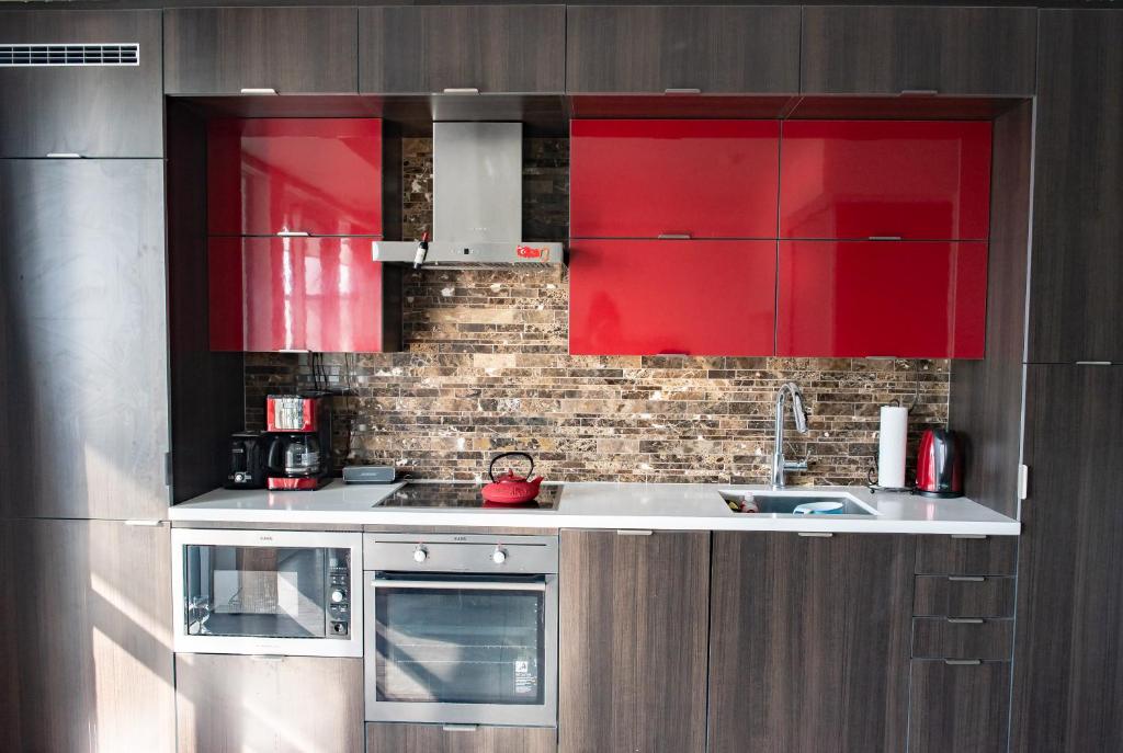 a kitchen with red cabinets and a sink at Luxury Adventure CN Tower/MTCC/Scotiabank Arena in Toronto