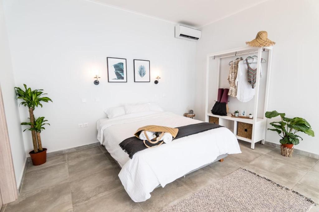 a white bedroom with a bed and a mirror at SECRET HILL in Athani