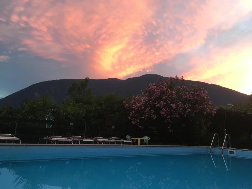 a swimming pool with a sunset in the background at Residence Bichler in Merano