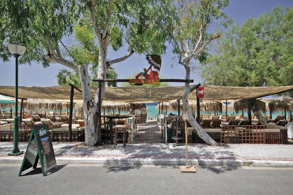 a patio with tables and chairs and a tent at FunBeach Rooms in Neos Marmaras