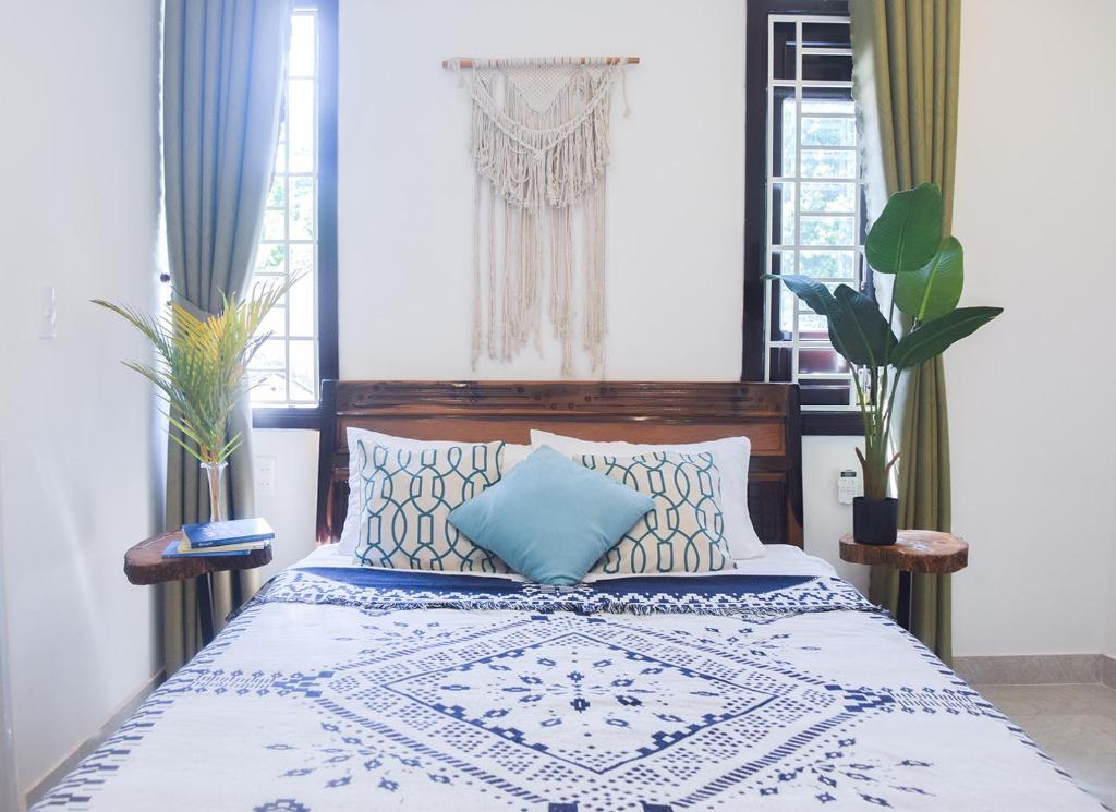 1 dormitorio con 1 cama con manta azul y blanca en GIA THÀNH HOMESTAY en Hoi An