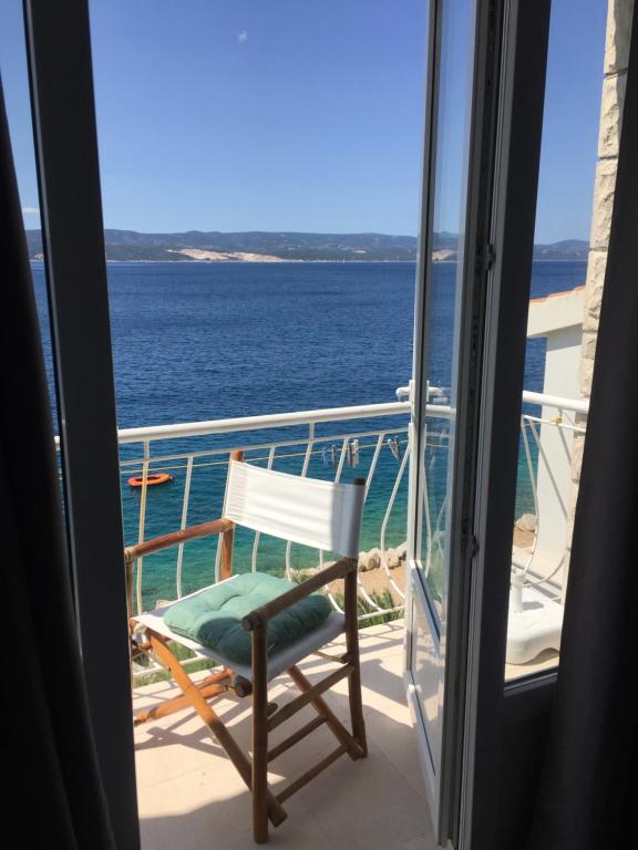 uma cadeira numa varanda com vista para o oceano em Rooms Pere s mora em Mimice