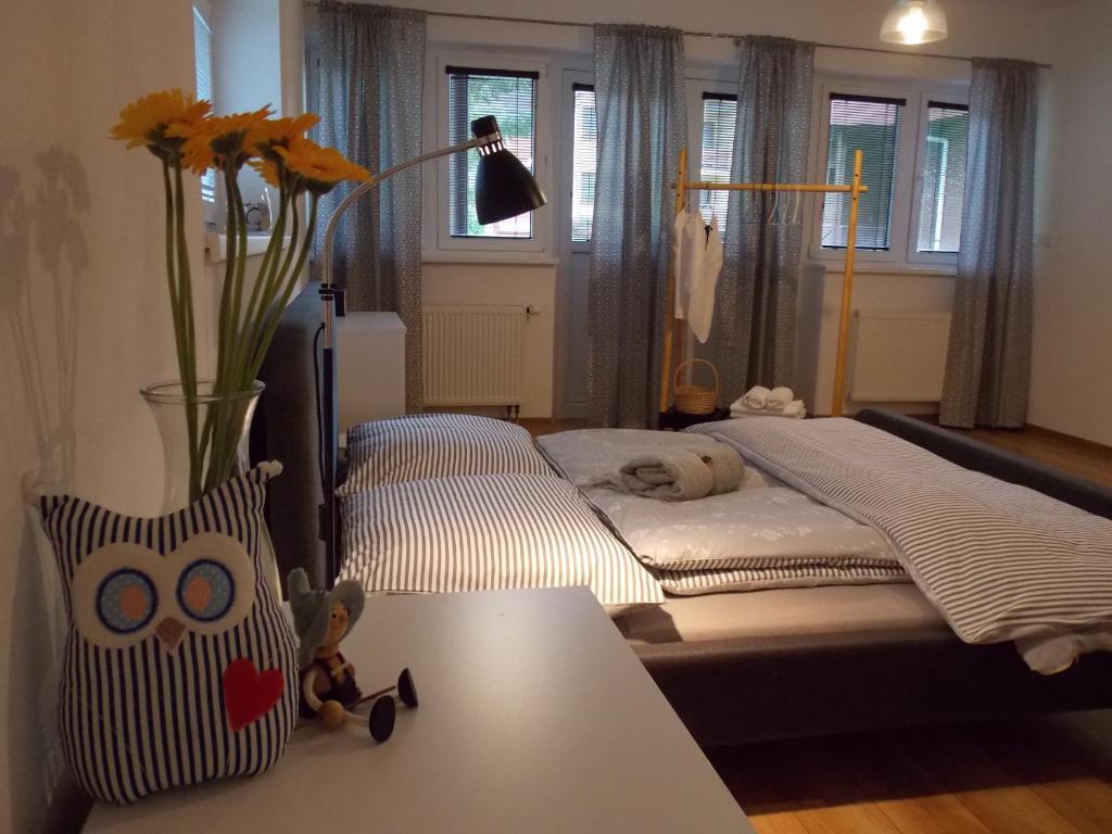 um quarto com uma cama e um vaso com flores sobre uma mesa em Happy Guests apartment em Poprad