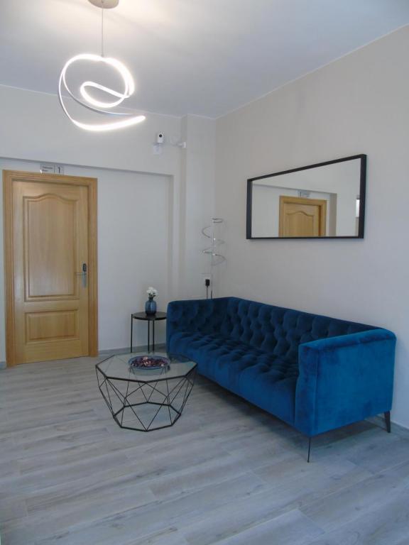 a living room with a blue couch and a table at Casa San Nicolás in Portomarin