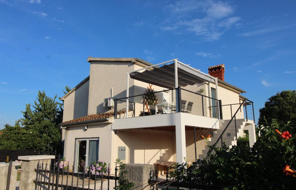 a large white house with a balcony with flowers at Apartment Mirella 1745 in Bale