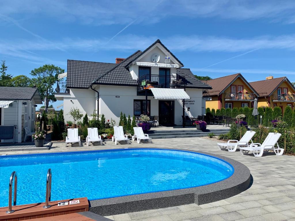 a swimming pool in front of a house at Apartamenty Różany Ogród in Łeba