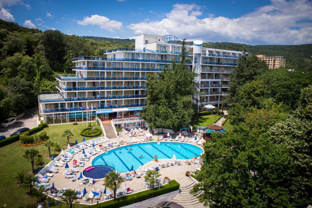 a hotel with a large swimming pool in front of a building at Park Hotel Perla in Golden Sands