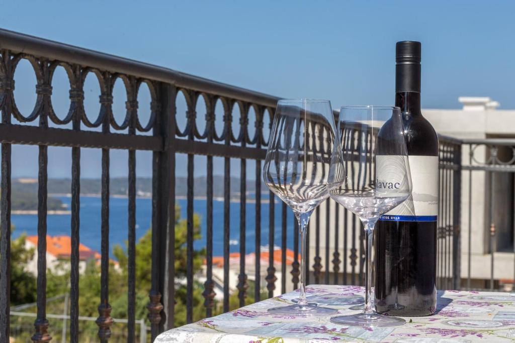 a bottle of wine and two glasses on a table at Guest House Milan in Hvar