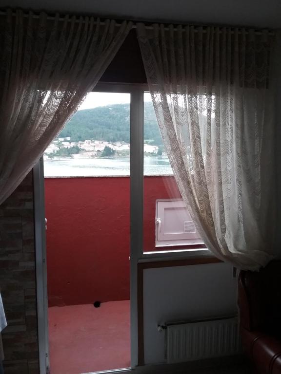 a view of a window with a view of the water at Ático vacacional in Muros