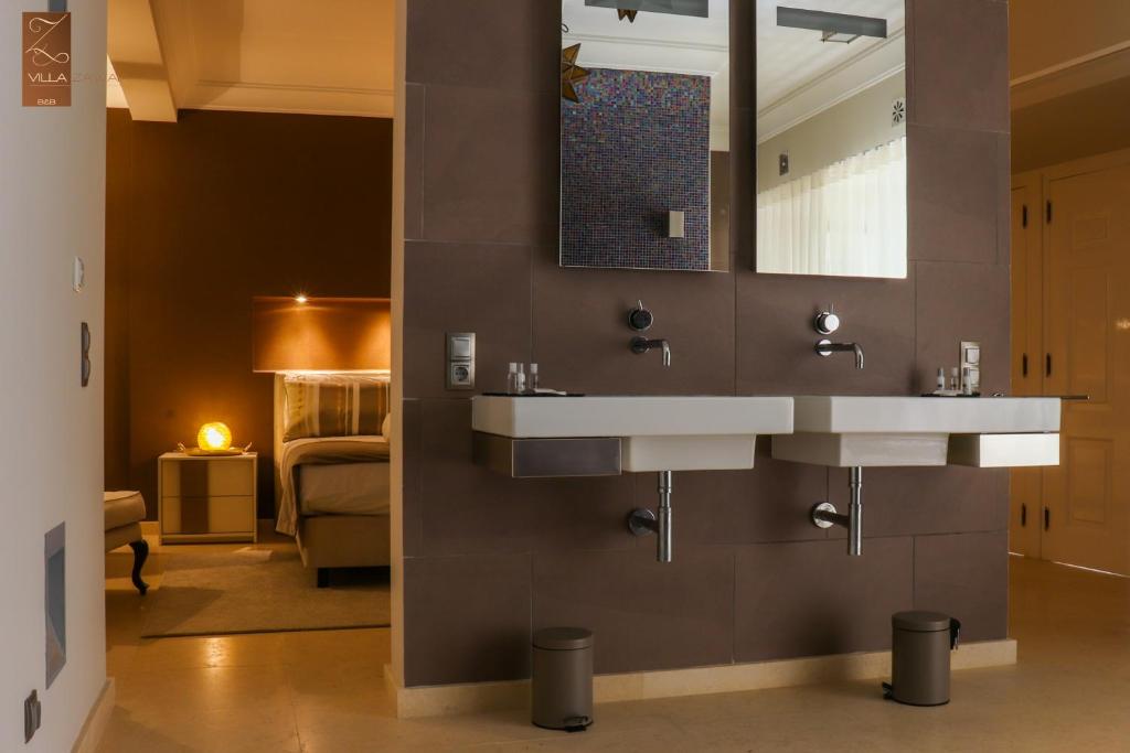 a bathroom with two sinks and a bedroom at Villa Zawaia B&B in Lagos