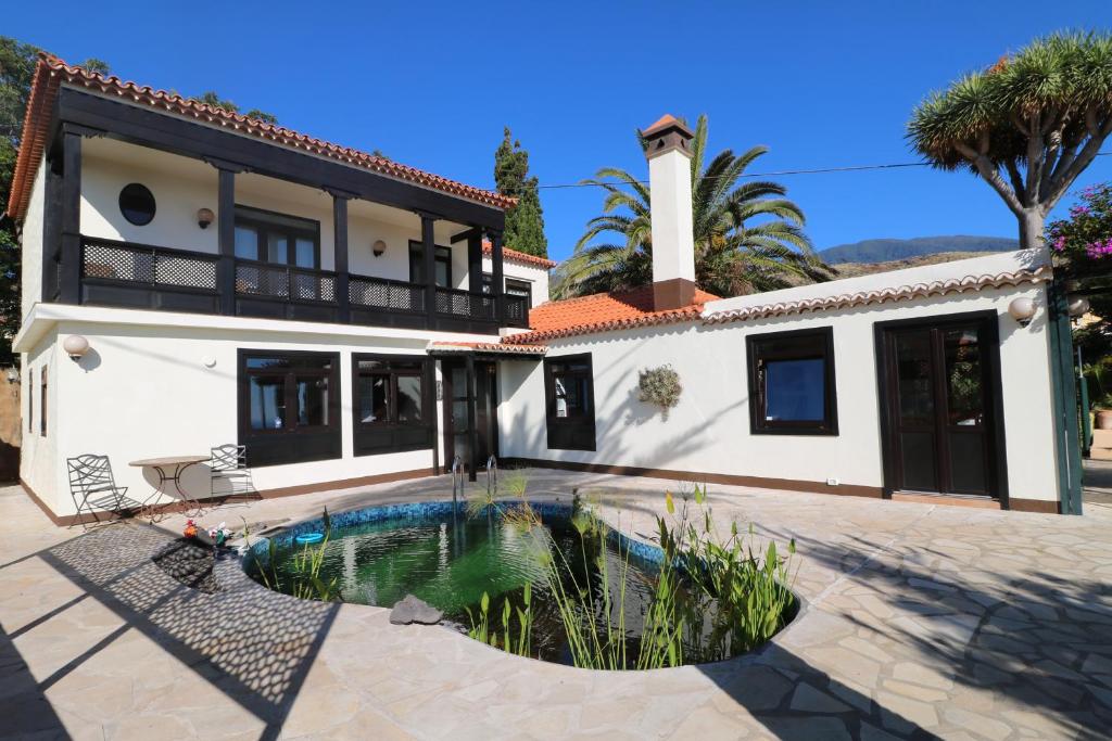 uma casa com uma piscina em frente em Villa Escondida em Breña Baja