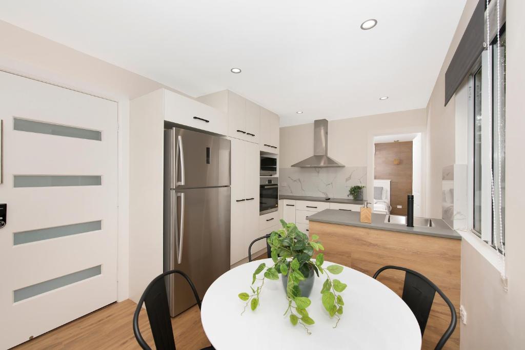 a kitchen with a table and chairs and a refrigerator at Cosy 2 bedroom home in Townsville