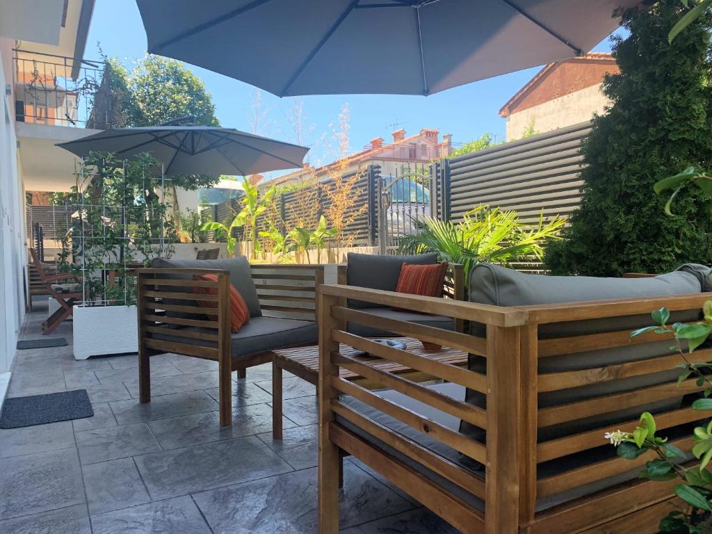 - une terrasse avec 2 bancs et un parasol dans l'établissement Apartments Artemus Karliva, à Izola