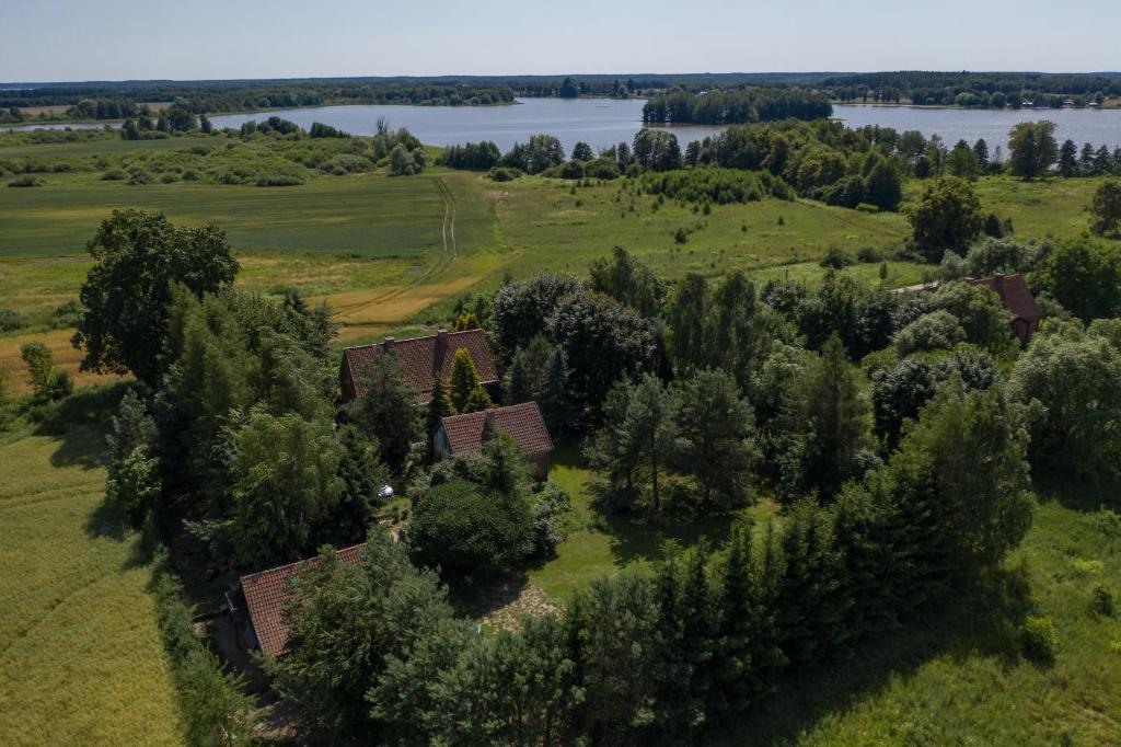 an aerial view of a house in a field with trees at Dziki brzeg Jezioraka in Plajny