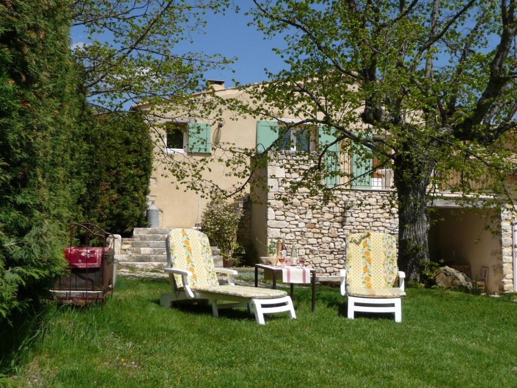 two chairs and a table in the yard of a house at Le Jas de Verdolier in Sault-de-Vaucluse