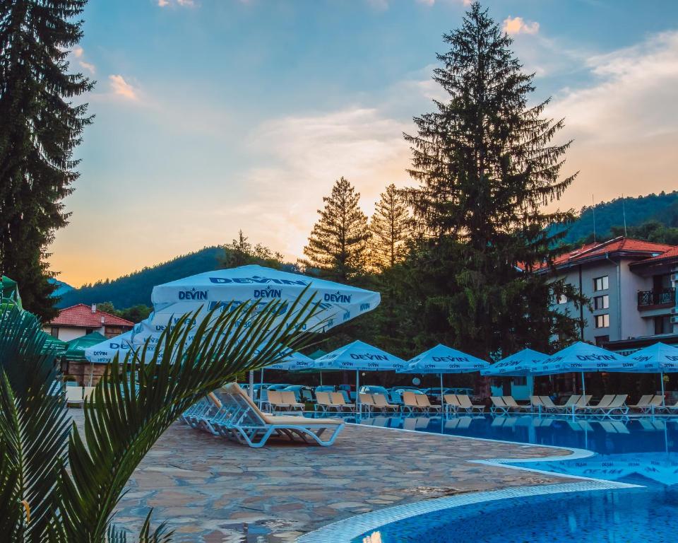 a resort with a pool with chairs and umbrellas at Ostrova Holiday Village in Beli Osŭm