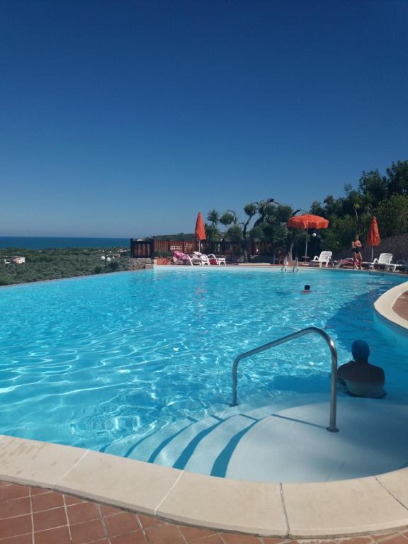 une grande piscine avec l'océan en arrière-plan dans l'établissement Villa dei pini, à Vieste