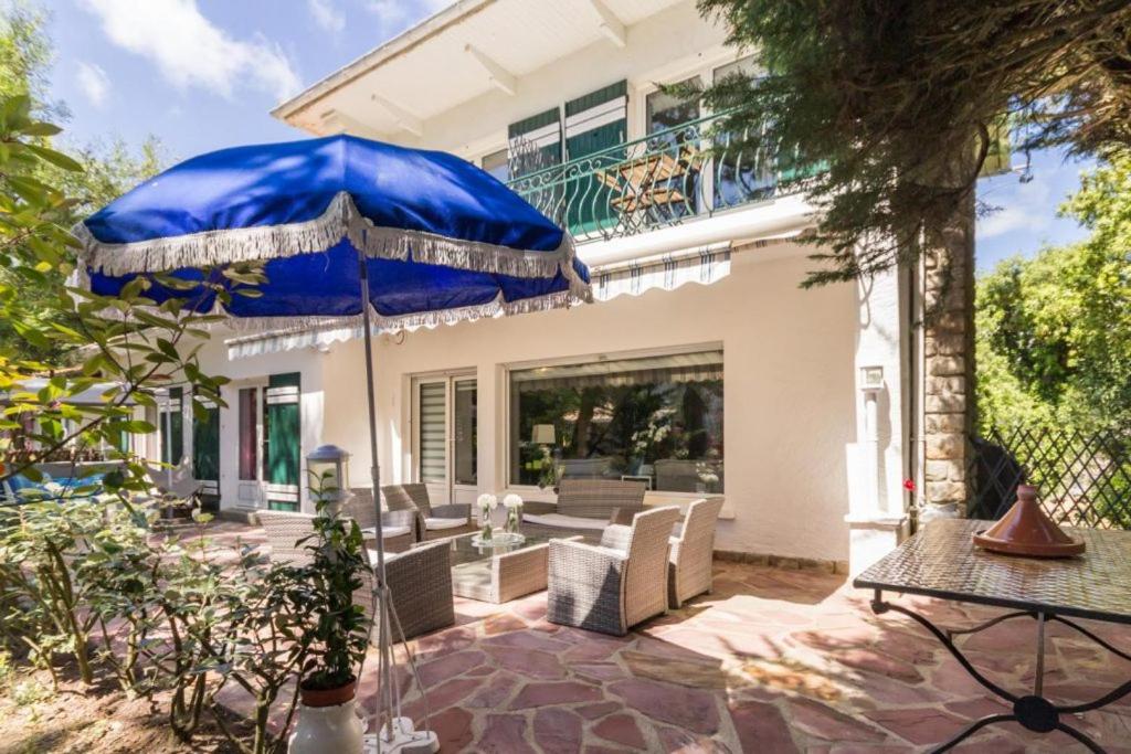 a large blue umbrella in front of a house at Villa Les Quatre Vents in La Baule