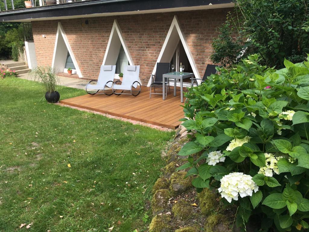 une terrasse en bois avec des chaises et une table sur une maison dans l'établissement Triangel, à Schmilau