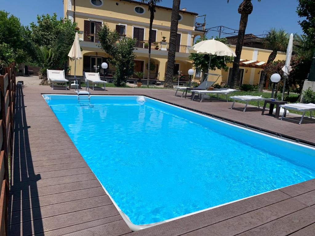 una gran piscina azul junto a un edificio en VILLA LUCIA, en Castellammare di Stabia