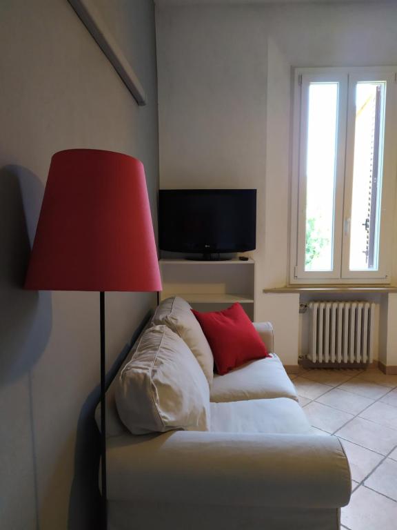 un soggiorno con divano e lampada rossa di Casa L'Osservanza a Cesena