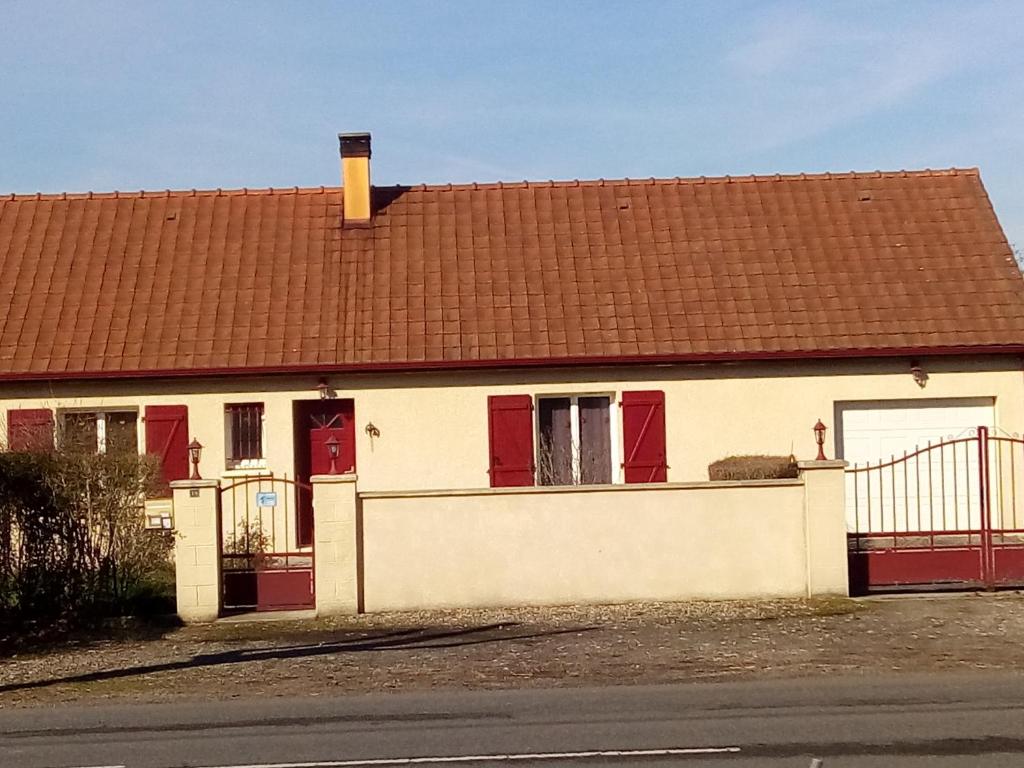 a white house with a brown roof and red doors at les vignes d'Ygrande in Ygrande