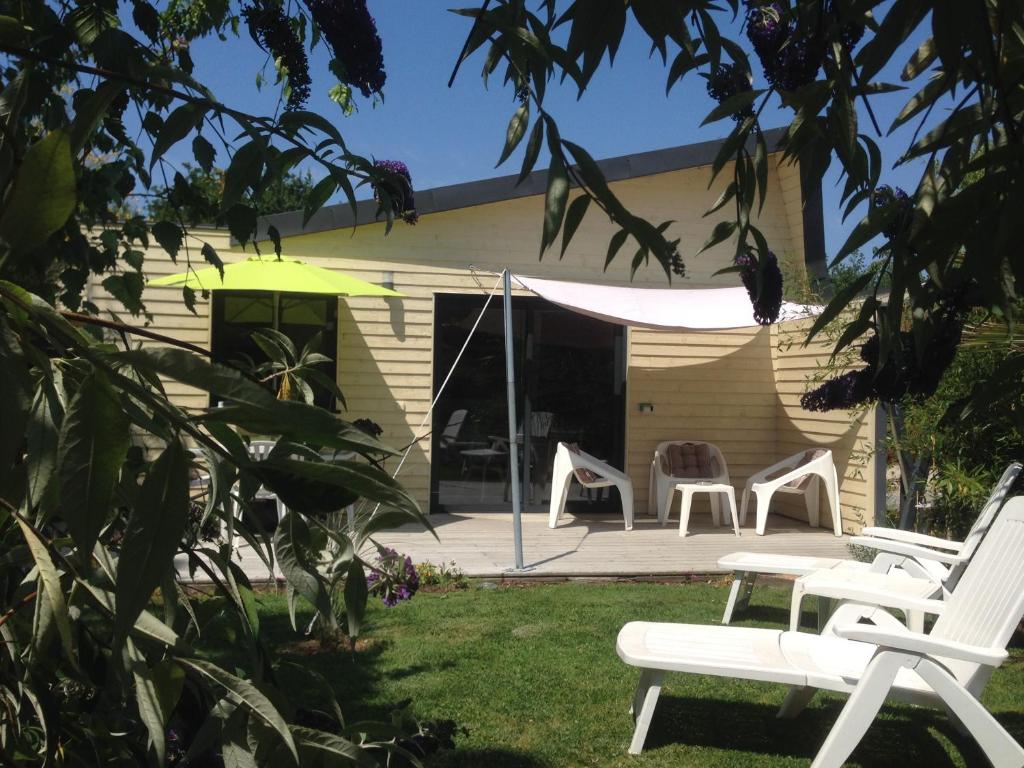 una casa con sillas y una tienda en el patio en Hameau de la Brelaudière en Jullouville-les-Pins