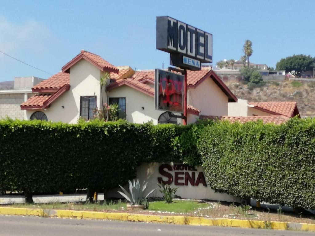 a house with a sign on the side of the street at MOTEL SENA in Ensenada