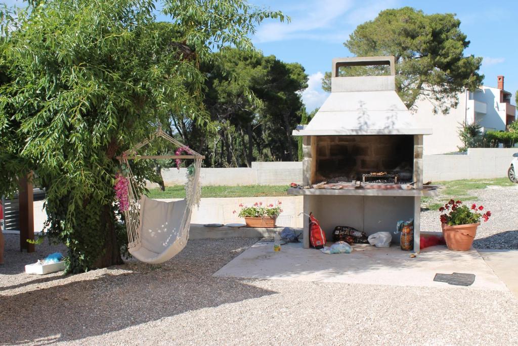 a outdoor grill with a hammock next to a tree at Apartments Borghetto in Vinkuran