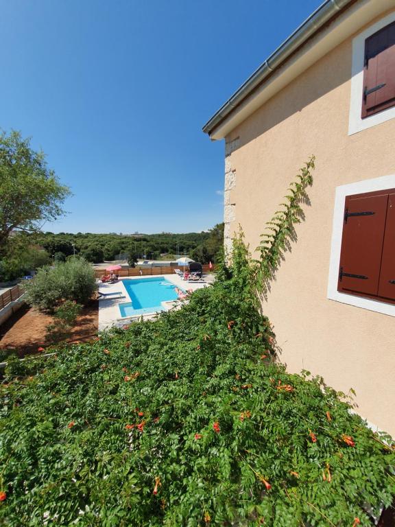 a ivy covered building next to a swimming pool at Apartments Borghetto in Vinkuran