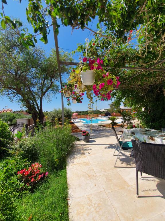 a patio with a table and chairs and flowers at Apartments Borghetto in Vinkuran