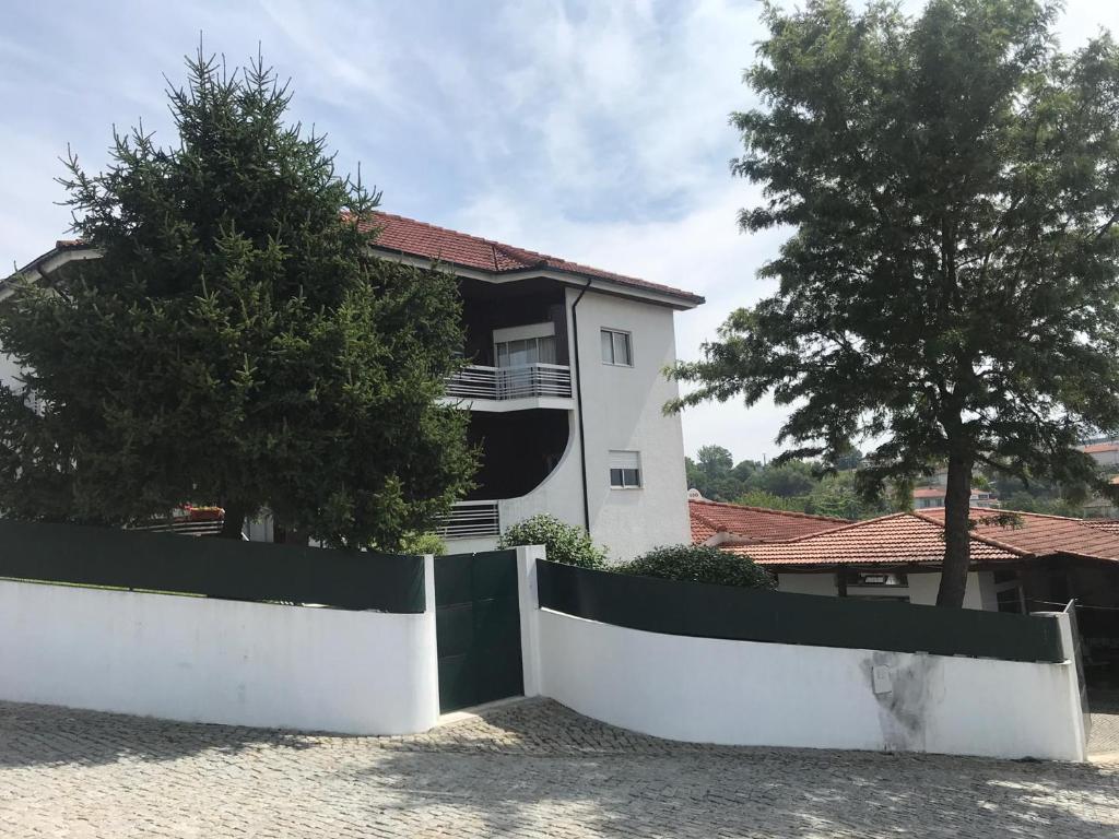 a white house with a fence in front of it at Casa do Nini in Amarante