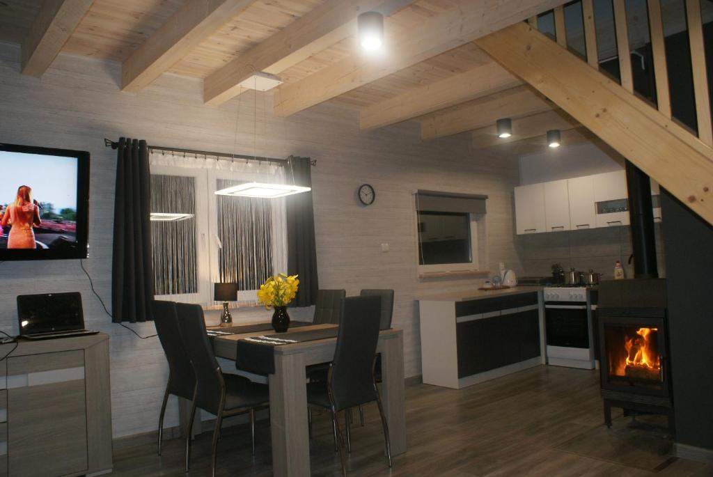 een keuken en eetkamer met een tafel en een open haard bij Agrodomki Okej-Biały Dom in Gardna Wielka