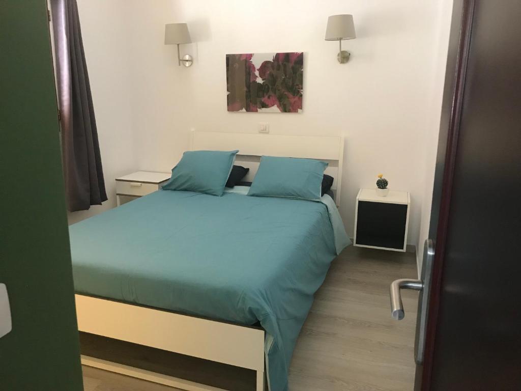 sypialnia z łóżkiem z niebieskimi poduszkami w obiekcie Los Panelos B1 w Puerto del Carmen