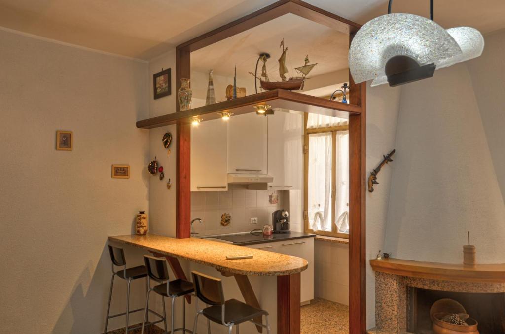 a kitchen with a counter and a kitchen with a fireplace at Casa Tinin in Loano