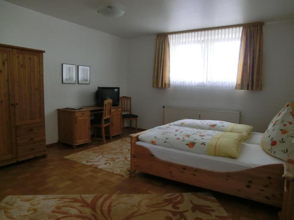 a bedroom with a bed and a window and a television at Fritz&#39;es Goldener Stern in Schauenburg