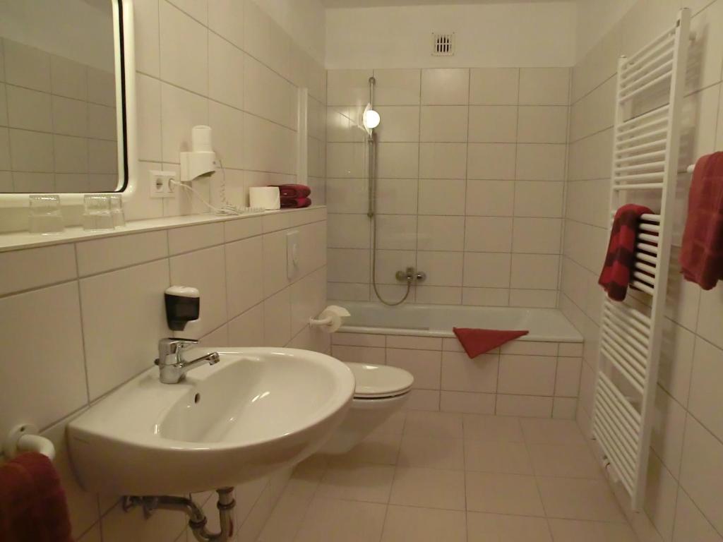 a bathroom with a sink and a toilet and a tub at Fritz&#39;es Goldener Stern in Schauenburg