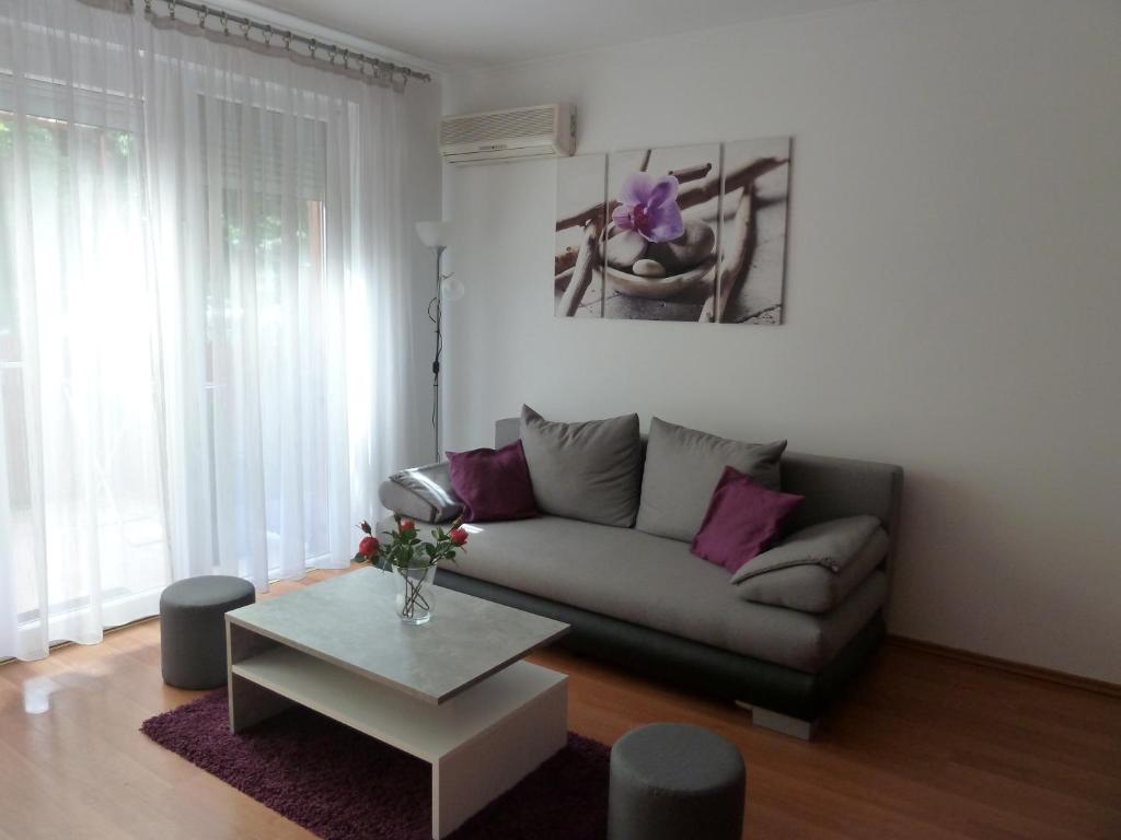 uma sala de estar com um sofá e uma mesa em ROSE Apartman em Debrecen