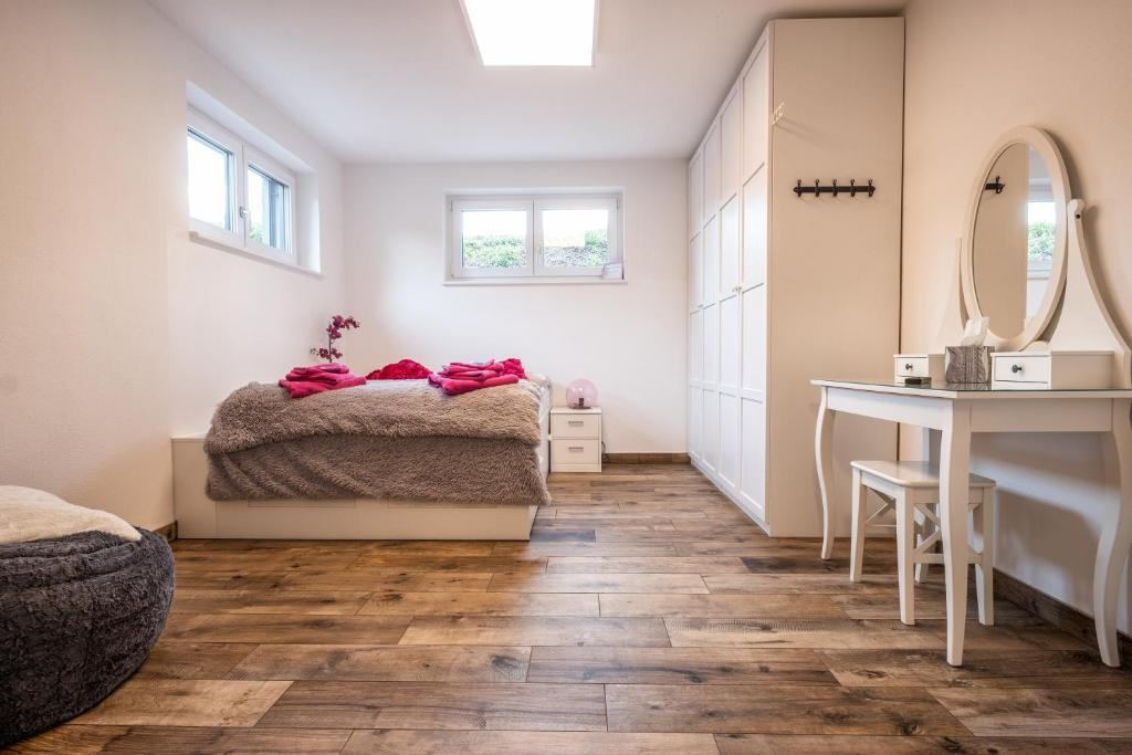 una camera con letto, tavolo e specchio di Moderne Souterrain-Wohnung ad Anif
