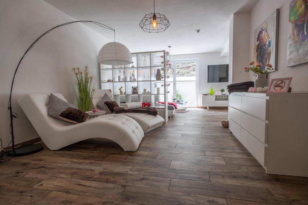un soggiorno con divano bianco e pavimenti in legno di Moderne Souterrain-Wohnung ad Anif