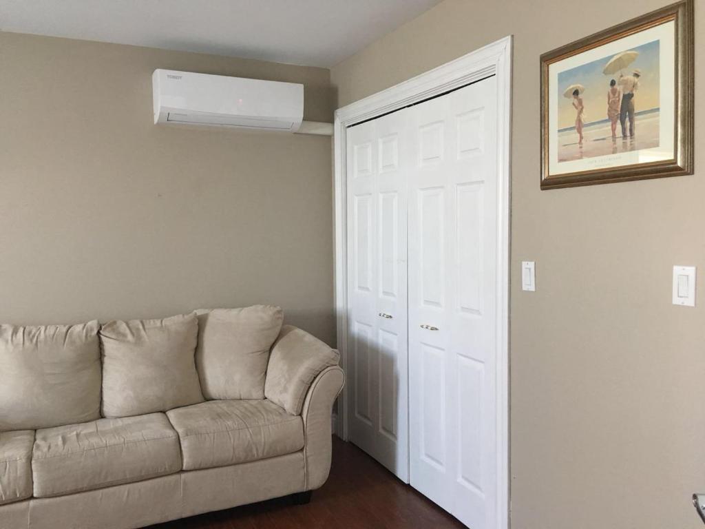 a living room with a couch and a white door at Seaview White House in Stratford