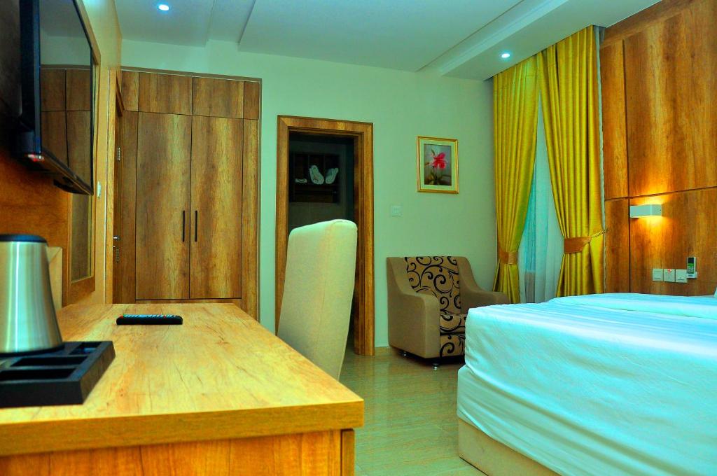 a hotel room with a bed and a desk with a desk at Lit Suites in Abuja