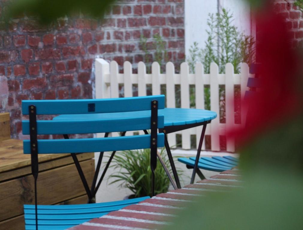 un banc bleu assis à côté d'une clôture blanche dans l'établissement La lisette, à Étretat