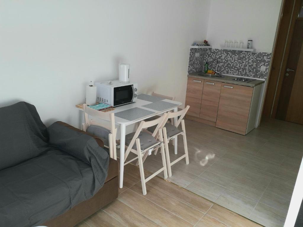 a kitchen with a table with a microwave and a couch at Mahala Guesthouse in Sarajevo