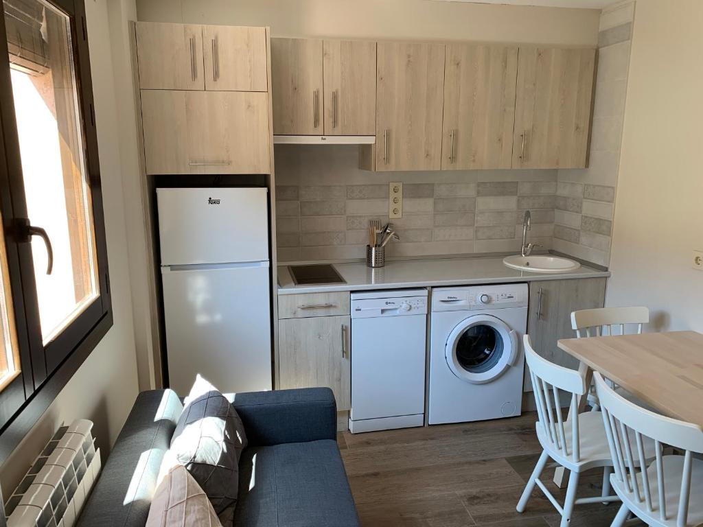 una cocina con refrigerador y lavadora y secadora en La Casa de los Molineros, en Albarracín