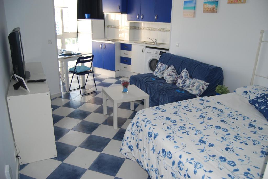 sypialnia z łóżkiem i kanapą oraz kuchnia w obiekcie M3 904 Azul Mediterráneo bonito y confortable estudio w mieście Benalmádena